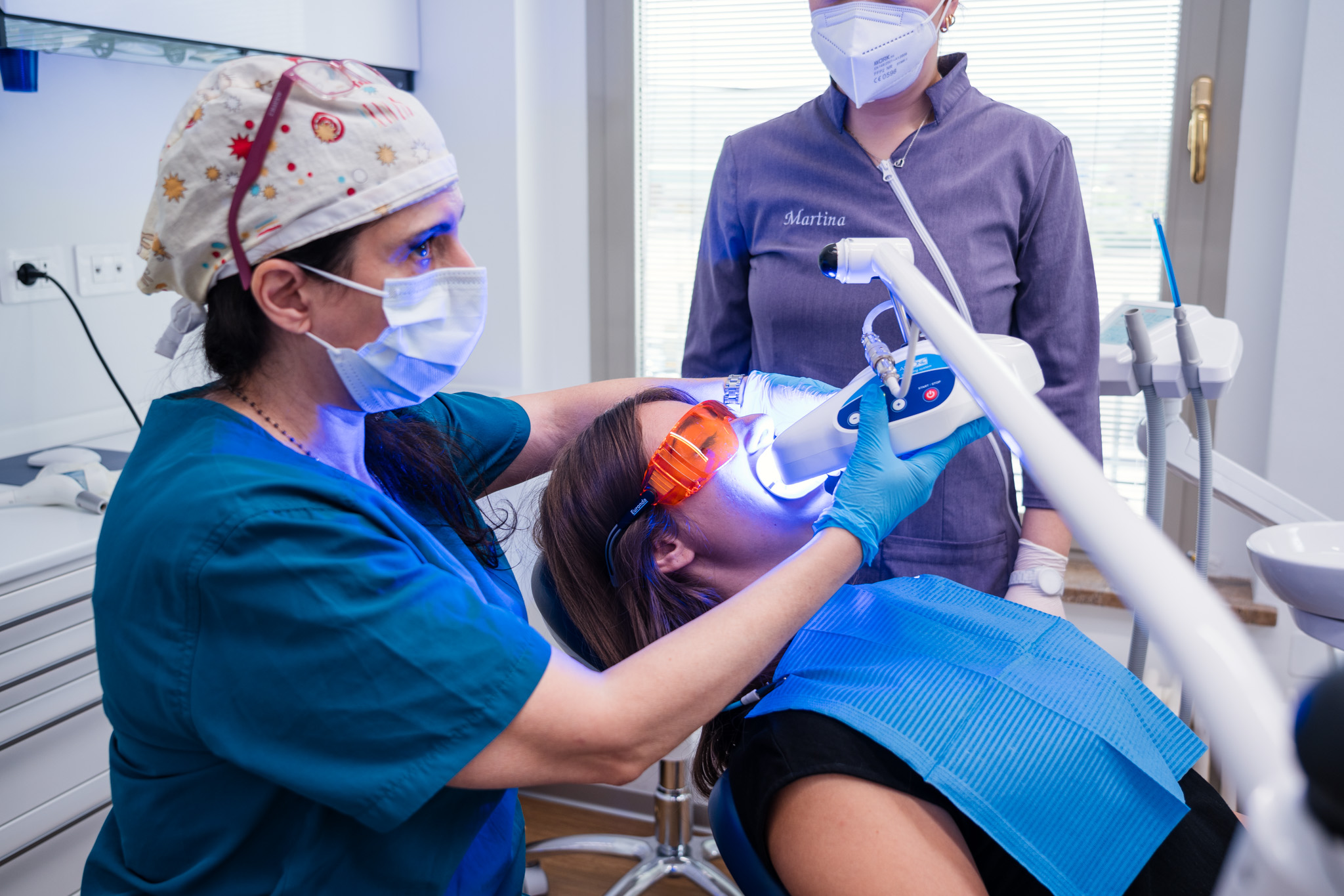 Dottoressa sulla poltrona che effettua lo sbiancamento dentale